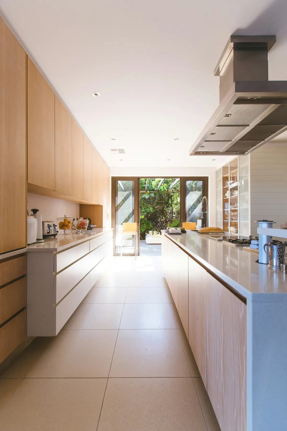 Lichte keuken met houten kasten en een deur naar de tuin
