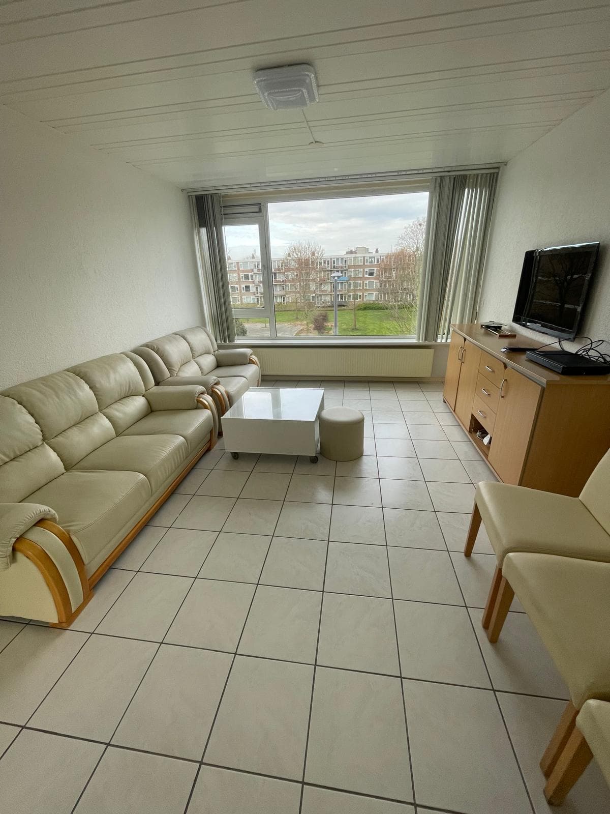 Lichte woonkamer met grote ramen.